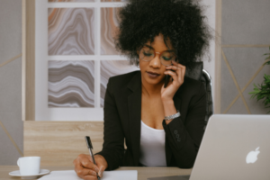 Women on her phone while writing a note