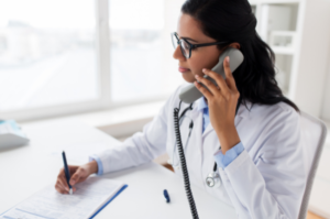 Doctor on her phone while taking notes