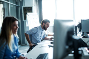 Men smiling at computer screen