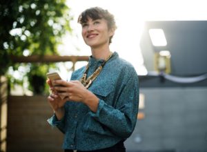 Women holding her phone in her hand while looking away