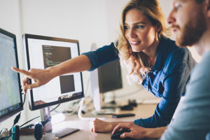 Women pointing to research on computer screen